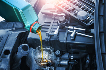 Refueling and pouring engine oil. Engine motor car maintenance. Lubricant oil for automobile. Close up on oil tank.