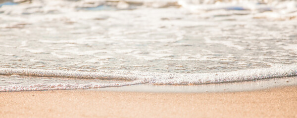 the waves of the sea on the sandy beach on a sunny day
