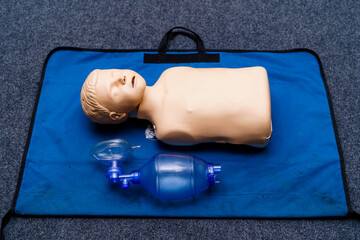 Medical doll lays on blue blanket ready for training. First medical help with oxigen masks.