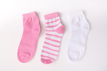 Three socks in pink color gamma, laying from white to pink close up on white background