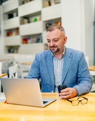 Senior businessman working on laptop computer. Confident CEO at office.