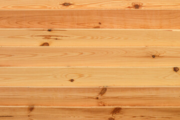 Fototapeta premium Texture of fresh wooden boards. Horizontal planks shield. Rough sawn pine boards stack on the construction site