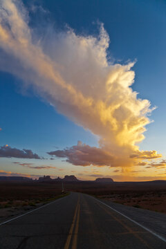 View of clouds over Monument Valley Navajo Tribal Park along Arizona Utah border at sunset