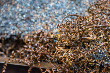 Steel scrap materials recycling. waste after machining metal parts on a cnc lathe. Closeup twisted spiral steel shavings. Small roughness sharpness