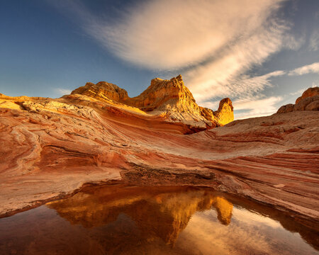Scenic view of striated sandstone against cloudy sky