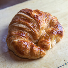 a croissant on a wooden board.