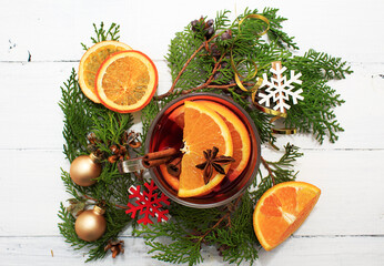 Home made mulled wine. Glass with orange slices, cinnamon sticks, cloves, cherry juce on white wooden background. Top vew, christmas decor