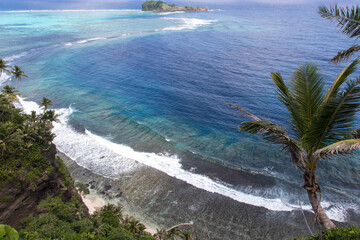 High angle view of fringing reef and shoreline with palm trees