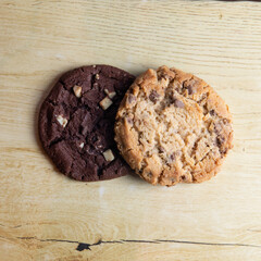 cookie with pieces of black and white chocolate on a wooden table.