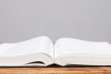 Open big book Bible on a wooden table. Close-up.