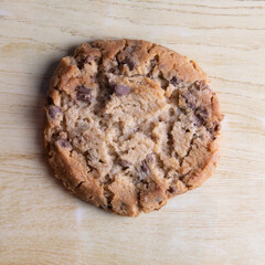cookie with pieces of black and white chocolate on a wooden table.
