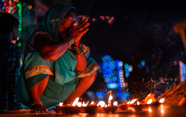 Closeup Middle-aged woman offers prayers with incense stick on the night of Diwali outdoors.