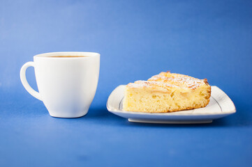 White ceramic cup of hot coffee and sweet pastries on blue background