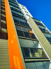 Corner of a multi-storey building against the sky with balconies.