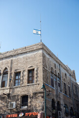 A flag flies over a beauitful stone building in Israel