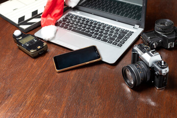 notbook next to a clapperboard. camera and handheld photometer, cell phone on wood in zenith plane and Christmas hat