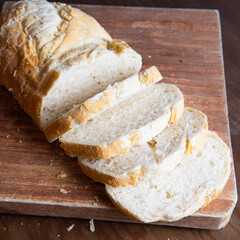 loaf of bread cut into pieces on a wooden board