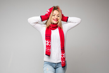 Stock photo of pretty jovial girl in knitted scarf and mittens messing her hair up with toothy...
