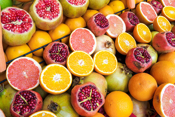 Pomegranates, oranges, grapefruits on counter at market in Turkey for make healthy juice. Top view, selective focus