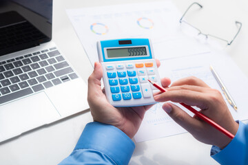 man hand use calculator with financial spreadsheet data