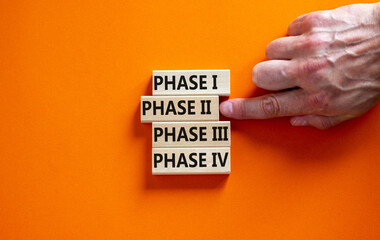 Time to phase 2. Wooden blocks form the words 'phase, 1, 2, 3, 4' on orange background. Male hand. Beautiful background. Business and covid-19 vaccine trial concept.