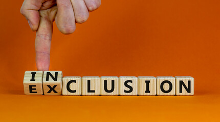 Symbol for a better inclusion. Hand turns cubes and changes the word exclusion to inclusion. Beautiful orange background. Business concept, copy space.