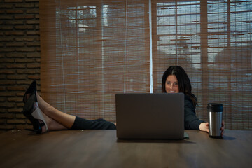 woman in high heels at a table teleworking