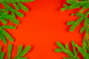 Christmas composition. Gifts, spruce branches, red shiny decorations on a red background. 