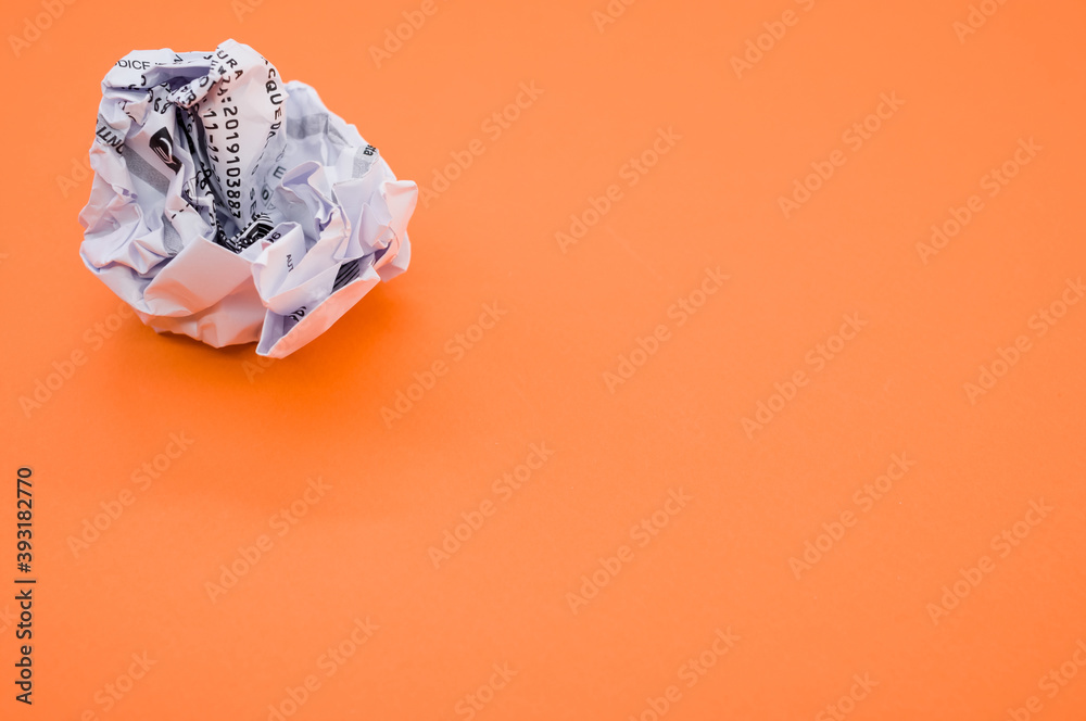 Sticker High angle shot of a wrapped paper ball isolated on an orange background