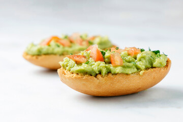 Guacamole toasts with tomato and parsley