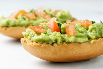 Guacamole toasts with tomato and parsley
