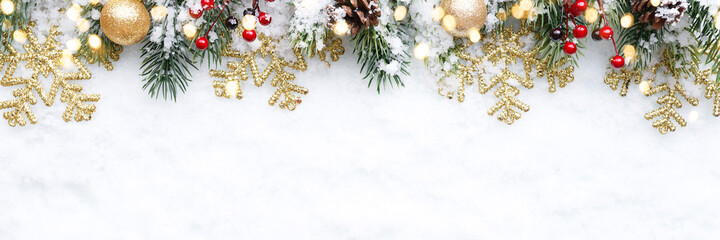 Christmas Border - tree branches with golden baubles, berries and snowflakes on snow
