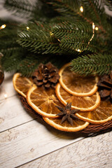 dried orange in a basket with garland and fir branches and cones. Christmas morning holiday concept. Flat lay.