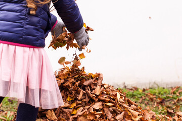 Little kids playing with autumn leaves outdoors. Autumn mood. Herbstliche Stimmung. Kleine Kinder spielen mit Blättern im Herbst im Freien.