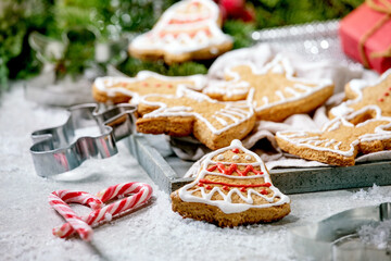 Homemade traditional Christmas gingerbread cookies with icing ornate. Gingerbread Man, angel, bell with xmas decorations over white bokeh background.