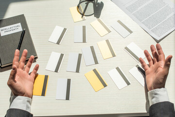 Cropped view of businessman hands near credit cards on white textured background