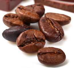 pieces of chocolate and roasted coffee beans isolated on white. close-up