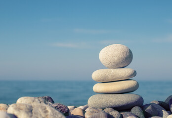 Pyramid of balanced stones on the background of the sea. Selective focus