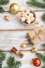 Christmas or New Year composition. Decorations, box, balls, fir and spruce branches, cup of coffee, on a white wooden background. Top view, copy space.
