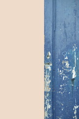 An old blue wooden door with powder pink in the background