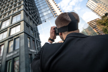 Man in black suit in vr glasses looking at the building