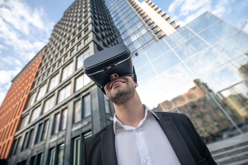 Man in black suit wearing vr glasses and looking enjoyed