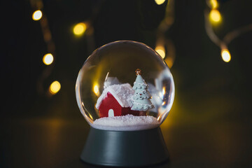 Crystal ball with snow with background lights. Copy space. Christmas concept.