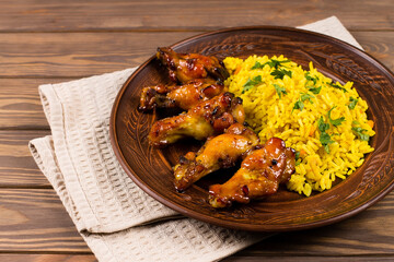 West African food. Rice with fried chicken, herbs and spices, on a plate