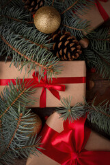 Gift box with red silk bow among Christmas decorations on a wooden table. Merry Christmas and Happy New Year Festive background.