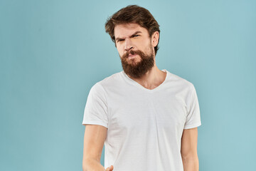 Obraz premium Man gestures with his hands emotions displeasure white t-shirt blue background