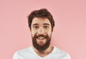 Portrait of a man in a white T-shirt on a pink background close-up model