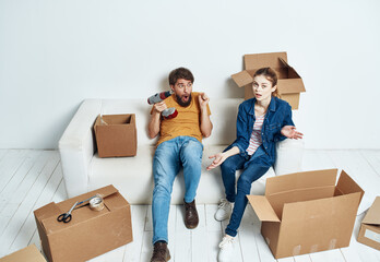 Fototapeta na wymiar family young couple on the couch fun moving boxes with things