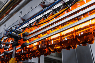 Plastic empty beer bottles on a conveyor belt. Industrial beer production
