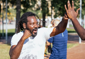 Afro man with dreadlocks training martial arts in a city park